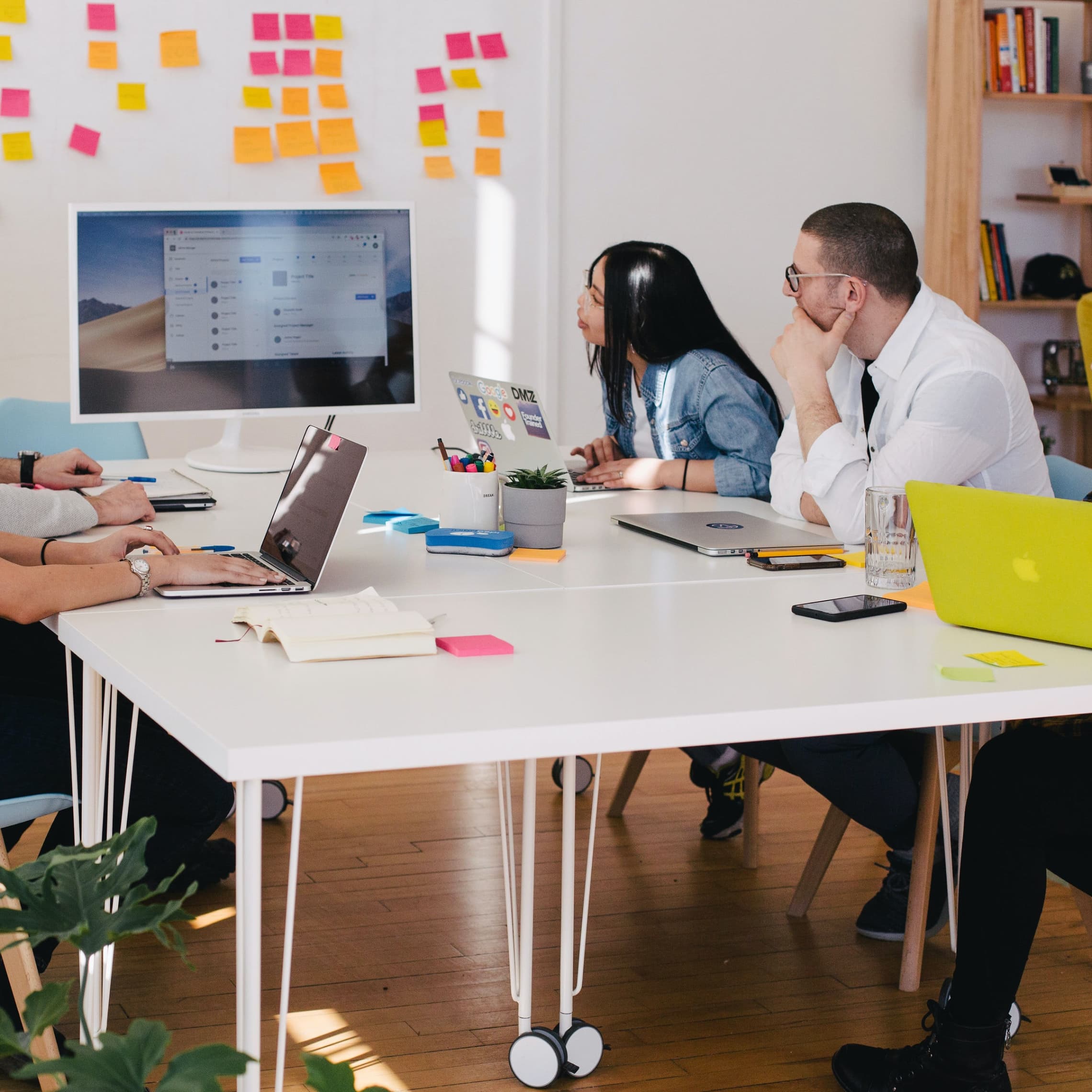 Five person by table watching turned on white iMac