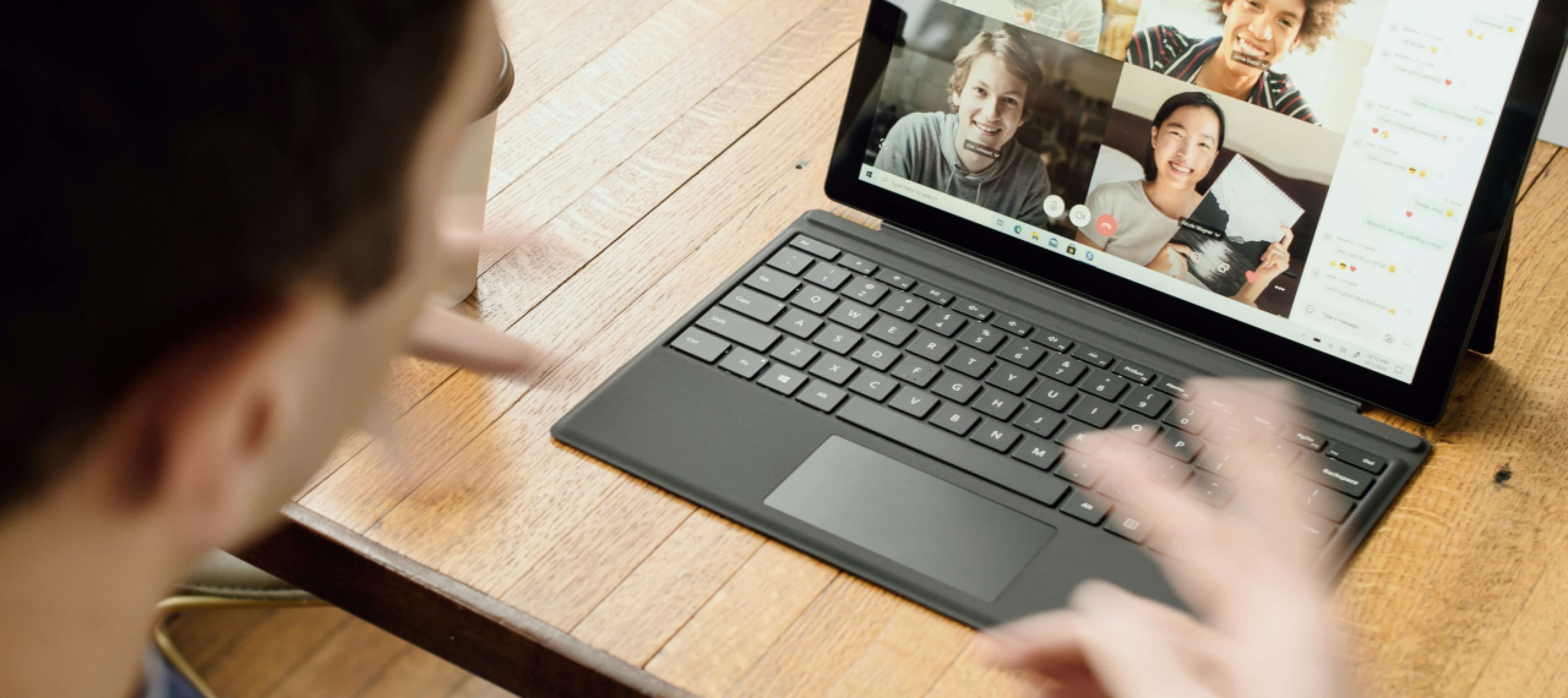 A cheerful man video chatting with friends on his laptop, sharing laughter and catching up on the latest news.